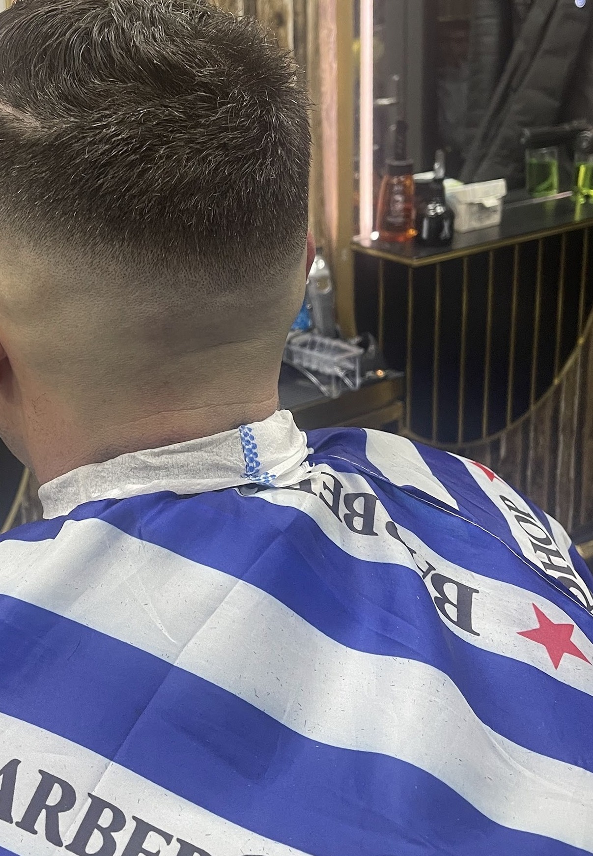Een strak afgewerkt herenkapsel met geleidelijke overgang, van achteren gezien